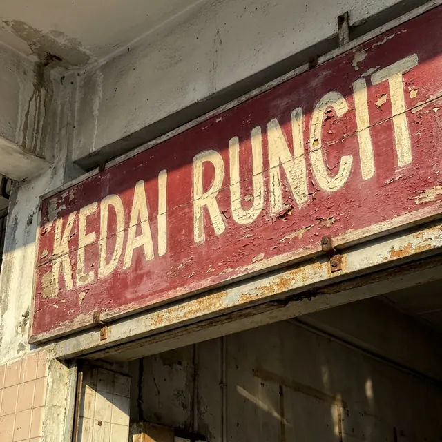 [object Object] — Hand-painted shophouse signage, faded by weather.