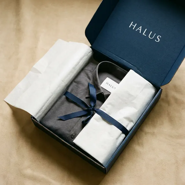 [object Object] — The lid half off, tissue folded back, the reveal beginning.